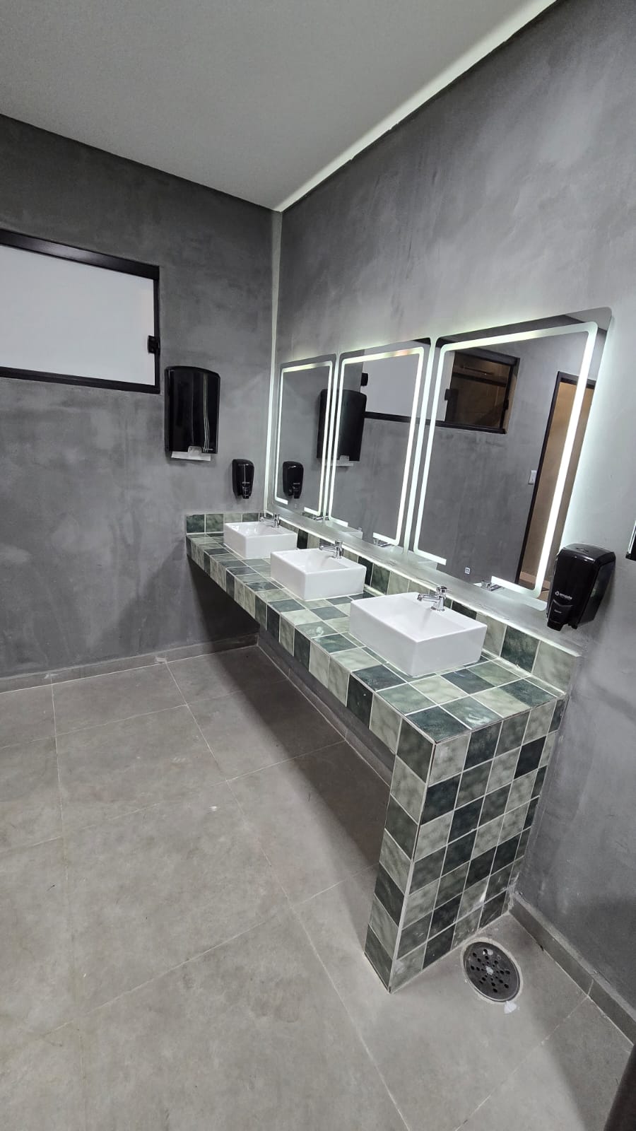 Vestiário com pias e espelhos iluminados